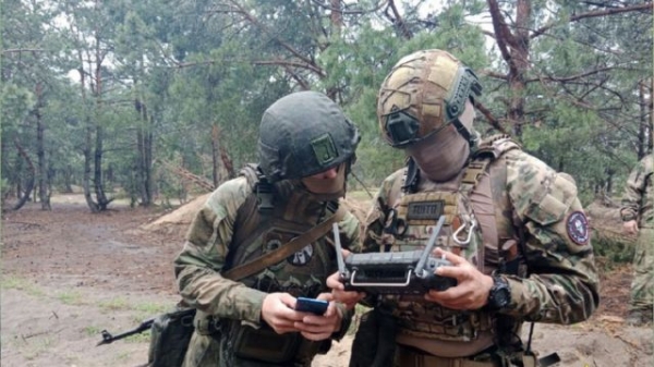 A Wagner mercenary training a Belarus soldier at a camp near the Polish border